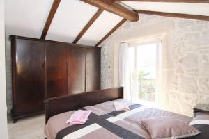 - une chambre avec un lit doté d'une tête de lit en bois et d'une fenêtre dans l'établissement Casa Ladonia, à Poreč