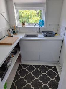 a small kitchen with a sink and a window at The Flat at Conway House in Overstrand