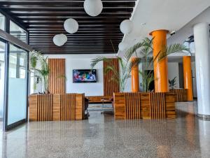 un vestíbulo con mesa, sillas y palmeras en Les Ombrelles Appart'Hotel en Cotonú