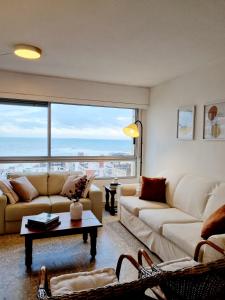 una sala de estar con 2 sofás y una ventana grande en TORRE806 VISTA MAR na PENÍNSULA en PUNTA DEL ESTE, en Punta del Este