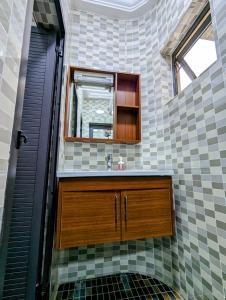 uma casa de banho com um lavatório e um espelho em Les Ombrelles Appart'Hotel em Cotonou