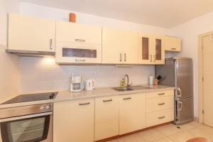 a kitchen with white cabinets and a stainless steel refrigerator at Lilly in Krk