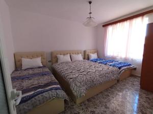 a bedroom with two beds and a window at RINA'S Apartment in Berat