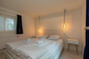 1 dormitorio con 1 cama blanca grande y 2 almohadas en Vakantiewoning - Valkenisseweg 68 l Biggekerke 'Strand Bungalow', en Biggekerke