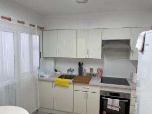 una cocina con armarios blancos y fregadero en PARRA HOME y garaje, Algemesi Home, en Algemesí