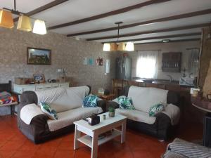 ein Wohnzimmer mit 2 Sofas und einem Tisch in der Unterkunft Alojamiento Rural Mi Frasca in Almodóvar del Río