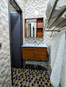 uma casa de banho com um lavatório e um espelho em Les Ombrelles Appart'Hotel em Cotonou