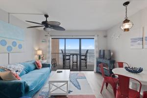 a living room with a blue couch and a table at Beachfront, Updated, Topsail Dunes Shining Sea in North Topsail Beach