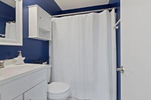 a bathroom with a white shower curtain and a toilet at Beachfront, Updated, Topsail Dunes Shining Sea in North Topsail Beach +10 photos