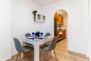 a kitchen with a table and chairs and a kitchen with a refrigerator at Espanatour CINUELICA III in Orihuela Costa +20 photos