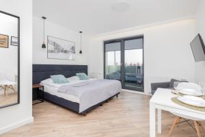 1 dormitorio con cama extragrande y mesa en Browar Gdański by Renters en Gdansk