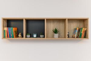 a wooden shelf with books and potted plants on it at Casa MILISMA in Braşov