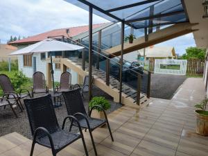 een patio met stoelen en tafels en een gebouw bij Hostel Pousada Casa da Praia in Passo de Torres