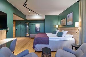 um quarto de hotel com uma cama e duas cadeiras em Scandic Lugnet em Falun