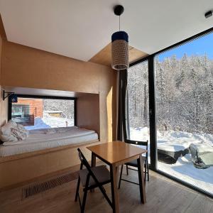 Habitación con cama, mesa y ventana en Apartamenty Szuflandia en Wisła