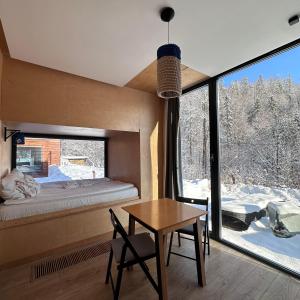 ヴィスワにあるApartamenty Szuflandiaのベッド、テーブル、窓が備わる客室です。