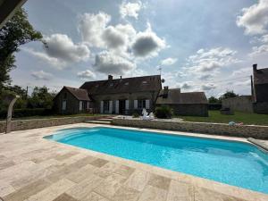 a swimming pool in front of a house at Charmante maison au coeur du Limousin - Comme à la maison in Lussac-les-Églises