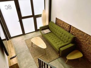 a living room with a green couch and a table at Stylish and Modern Loft in Madrid Centre in Madrid