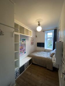een kleine slaapkamer met een bed en een raam bij Centrally Located 4 Room Apartment in Kopenhagen