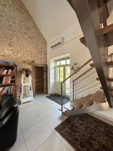 a living room with a staircase and a couch at Charmante maison au coeur du Limousin - Comme à la maison in Lussac-les-Églises