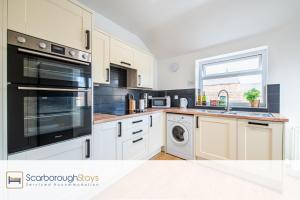 a kitchen with white appliances and a window at Hampton House - Lovely and Spacious 2 Bedroom Apartment - WITH FREE PARKING in Scarborough