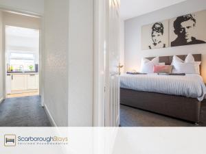a bedroom with a bed with white walls at Hampton House - Lovely and Spacious 2 Bedroom Apartment - WITH FREE PARKING in Scarborough