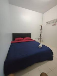 ein großes blaues Bett mit roten Kissen in einem Zimmer in der Unterkunft FZHomestays In CH in Cameron Highlands