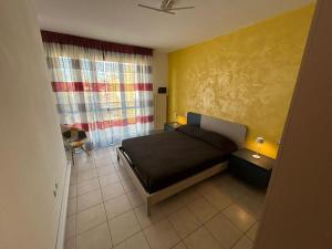 1 dormitorio con cama y pared amarilla en Ca'Vio Beach & Pool, en Cavallino-Treporti