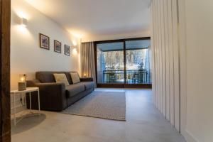 a living room with a couch and a large window at Alpesmith - Bike & Ski apartments in Bardonecchia