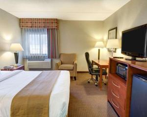 a hotel room with a bed and a desk with a television at Quality Inn Jessup - Columbia South Near Fort Meade in Jessup