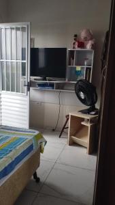 a bedroom with a bed and a desk with a television at Equilibra Soul in Caraguatatuba