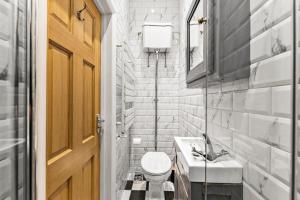 La salle de bains est pourvue de toilettes, d'un lavabo et d'une porte. dans l'établissement Remarkable Penthouse - Sea Views, à Worthing