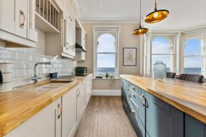 - une cuisine avec des placards blancs et un comptoir offrant une vue sur l'océan dans l'établissement Remarkable Penthouse - Sea Views, à Worthing
