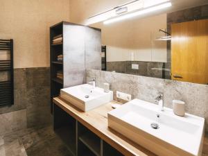 Baño con 2 lavabos y espejo en Apartment Alpenherz en Ried im Oberinntal