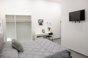 a bedroom with a bed and a desk and a television at Napoli Skyport in Naples