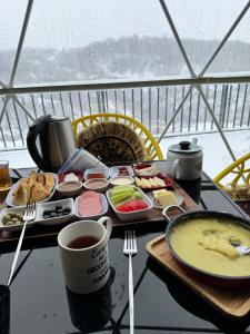 a table with a tray of food and a cup of coffee at Glamping Dream Domes Ismayilli in İsmayıllı