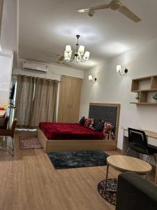 ein Schlafzimmer mit einem Bett mit einer roten Decke in der Unterkunft Khushi Home Inn in Noida