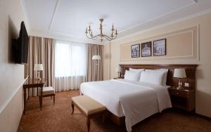 a hotel room with a large bed and a chandelier at Radisson Hotel Ulyanovsk in Ulyanovsk