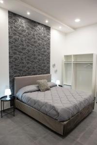 ナポリにあるNapoli Skyportのベッドルーム1室(壁に大型ベッド1台付)
