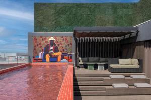 a man sitting on a chair on a roof at Radisson RED Hotel Johannesburg Rosebank in Johannesburg