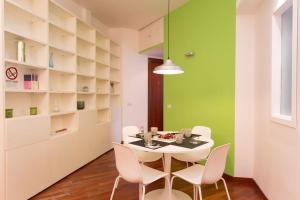 jadalnia ze stołem i krzesłami oraz zieloną ścianą w obiekcie Podesti House - Flaminio Stadio Olimpico w Rzymie
