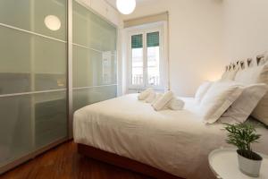 - une chambre blanche avec un grand lit et des oreillers blancs dans l'établissement Podesti House - Flaminio Stadio Olimpico, à Rome