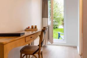 a wooden desk with a chair next to a door at Sure Hotel by Best Western Plaisir in Plaisir