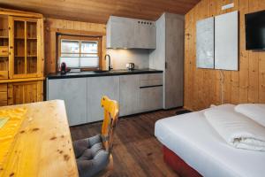 a kitchen with a bed and a table in a room at kleine Blockhütte in Ried im Oberinntal