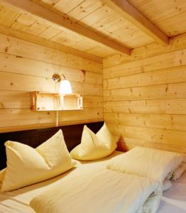 1 dormitorio con 1 cama en una habitación de madera en Blockhütte Bergzauber, en Ried im Oberinntal