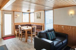 a living room with a table and a leather couch at Mobilheim Alpina in Ried im Oberinntal