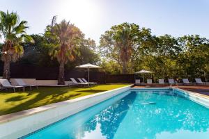einen Pool mit Stühlen und Sonnenschirmen im Hof in der Unterkunft Zenitude Hotel la Valadiere, Ascend Hotel Collection in Montpellier
