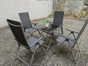 drei Stühle und ein Tisch mit einer Topfpflanze in der Unterkunft Geräumige helle Wohnung im grünen Taunus mit Privatparkplatz in Schlangenbad + 5 Fotos