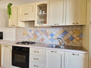 A kitchen or kitchenette at Le Melodie - Appartamenti con spazi esterni privati a Sos Alinos