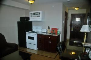 a kitchen with a white stove and a black refrigerator at Days Inn by Wyndham Athabasca in Athabasca